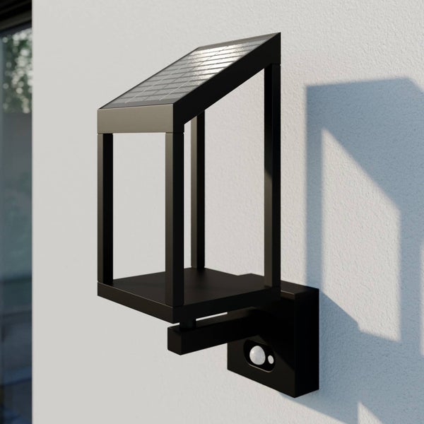 Moderne Solar-Außenwandleuchte in Schwarz mit Bewegungsmelder, montiert an einer Hauswand.