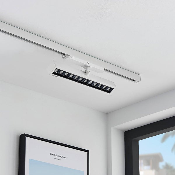 Moderne Schienenbeleuchtung mit rechteckigem LED-Strahler und mehreren Lichtquellen an einer Deckenschiene.