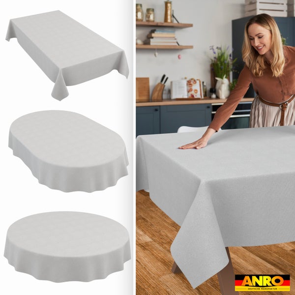 Rechteckige, ovale und runde Tischdecken. Eine Frau glättet eine Tischdecke auf einem Tisch in einer hellen Küche. ANRO Logo.
