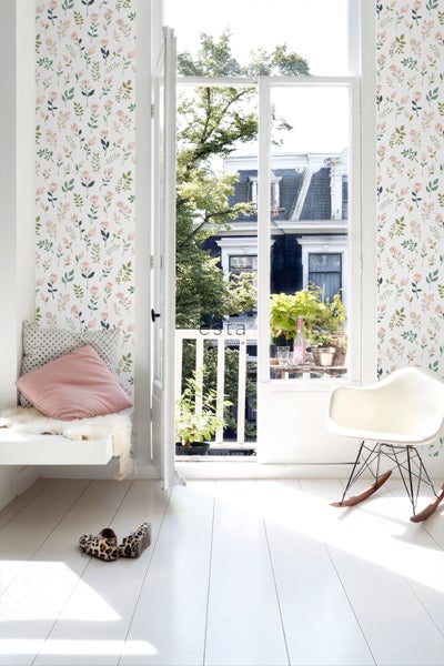 Heller Raum mit floral gemusterter Tapete, Sitzgelegenheit und offenem Balkon