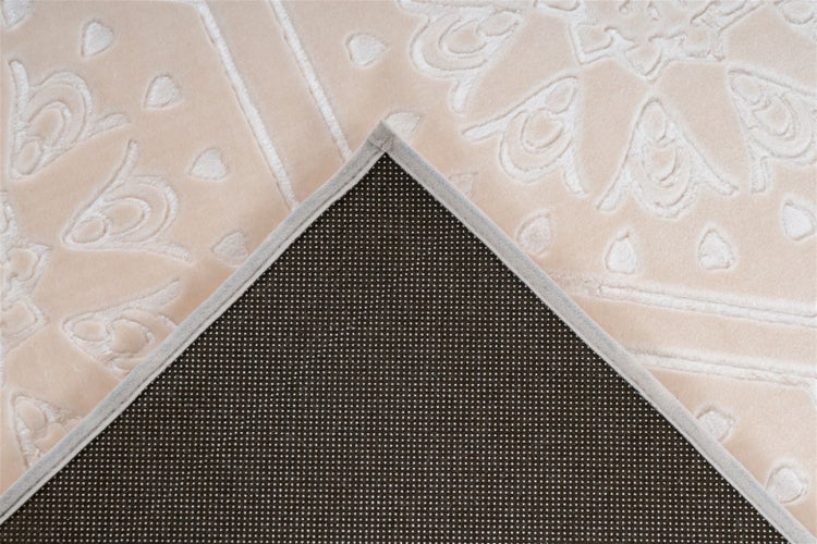 Detailansicht eines Teppichs mit geprägtem Muster und rutschhemmender Rückseite mit Noppen.