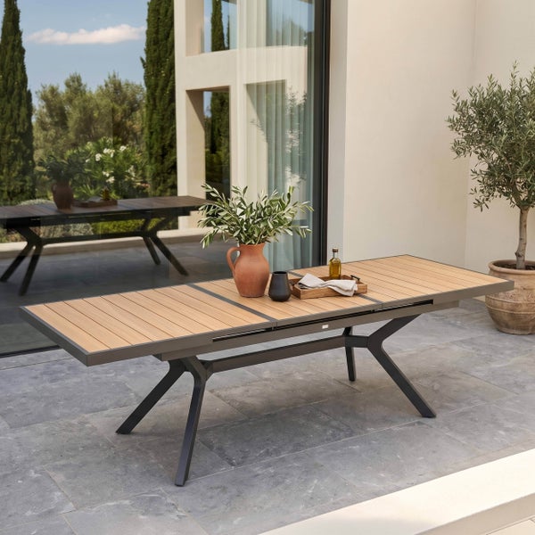 Moderner ausziehbarer Gartentisch mit Holzlamellen und Metallgestell auf einer hellen, geräumigen Terrasse mit Steinboden.