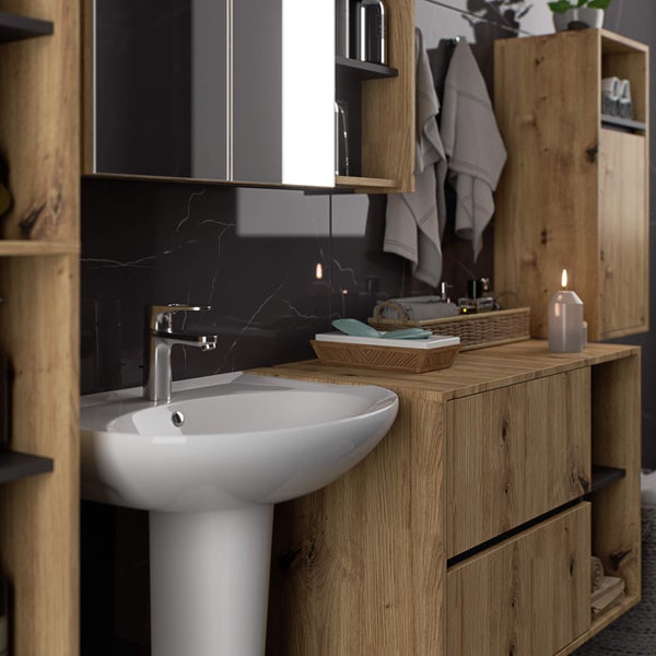 Badezimmer mit Waschtisch, Spiegelschrank und Hochschrank in Holzoptik vor dunkler Marmorwand