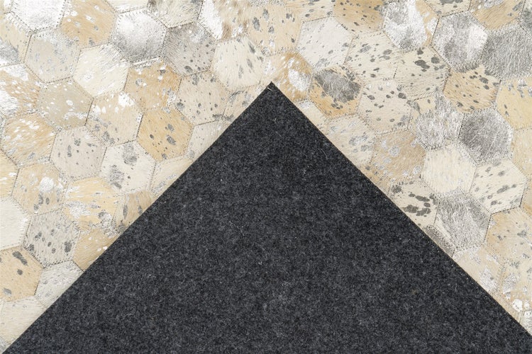 Patchwork-Teppich aus sechseckigen Kuhfell-Stücken mit Metallic-Akzenten und dunkelgrauer Filzrückseite.