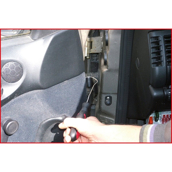 Handwerker demontiert Türverkleidung mit Schraubendreher