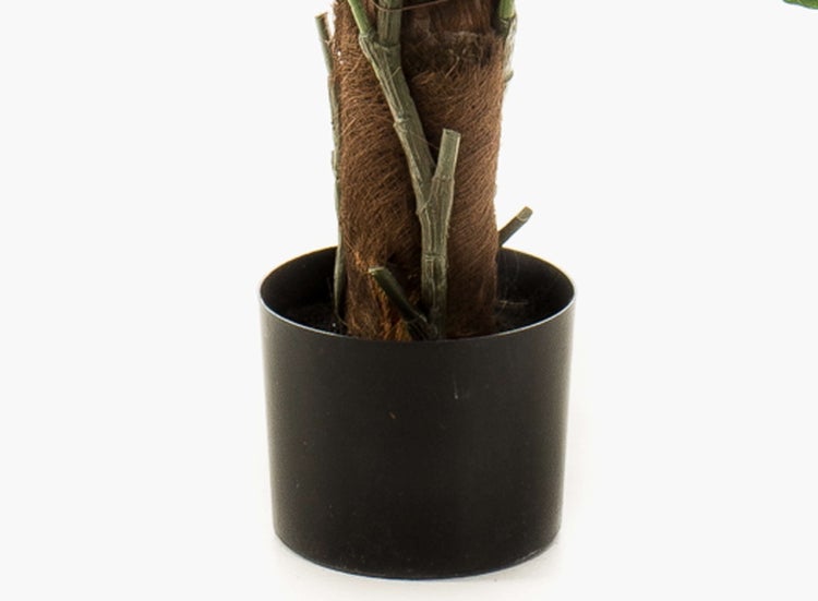 Künstliche Pflanze mit lila Blüten und grünen Blättern.