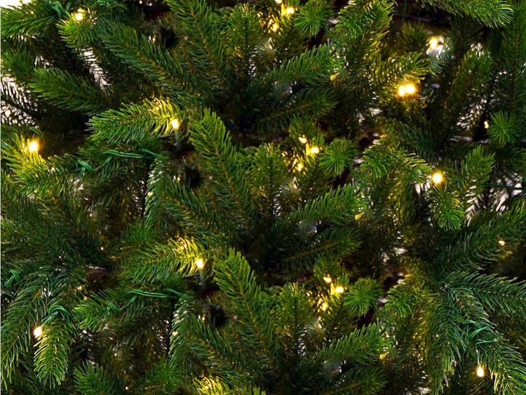 Detailansicht eines künstlichen Tannenbaums mit integrierter LED Lichterkette für eine stimmungsvolle Weihnachtsdekoration