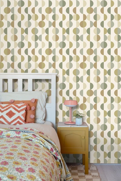 Vliestapete mit geometrischem Muster aus Kreisen und Halbkreisen im Retro-Stil in einem Schlafzimmer mit weißem Holzbett und gelbem Nachttisch.
