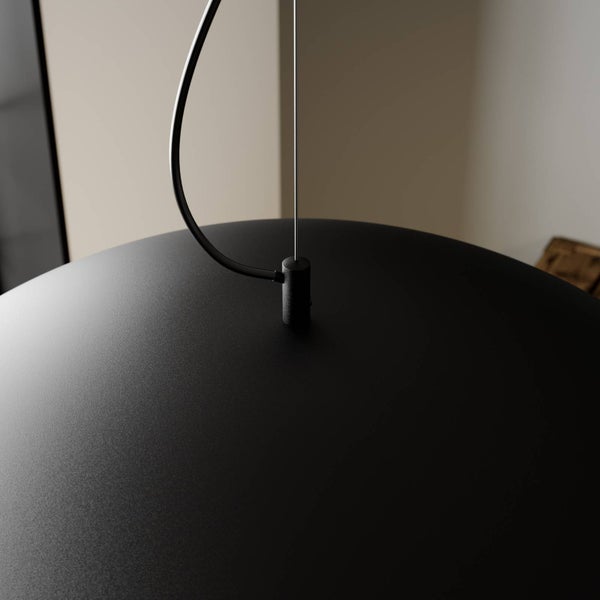 Detailansicht einer schwarzen matten Pendelleuchte mit Stromkabel und dünner Drahtseilaufhängung.