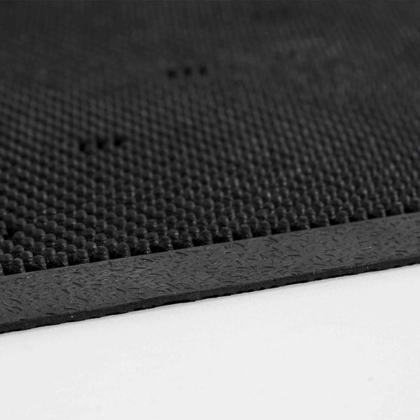 Detailansicht einer schwarzen Gummimatte mit Noppenstruktur