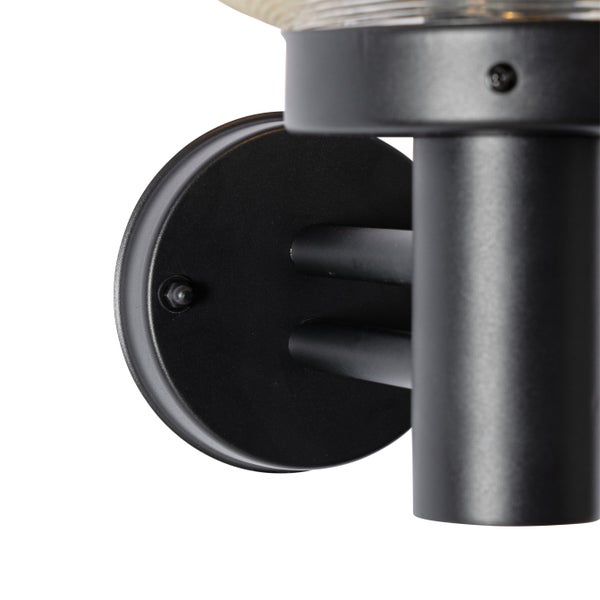 Nahaufnahme einer schwarzen Außenwandleuchte mit runder Wandhalterung und zylindrischem Lampenkörper.