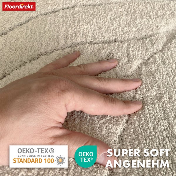 Person berührt weichen Teppich mit dem Oeko-Tex Standard 100 Siegel und dem Floordirekt Logo