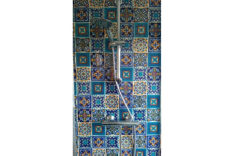 Dusche mit blau gemusterten Fliesen