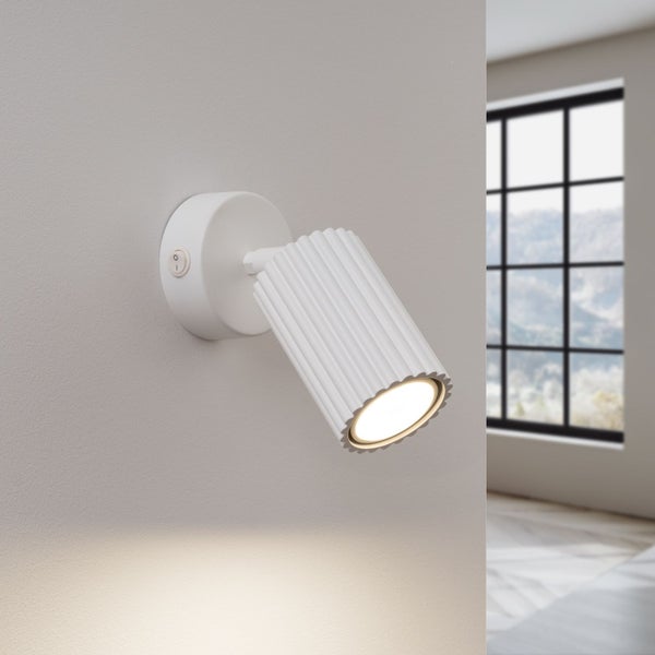 Weiße Wandleuchte mit Lichtkegel in einem Zimmer