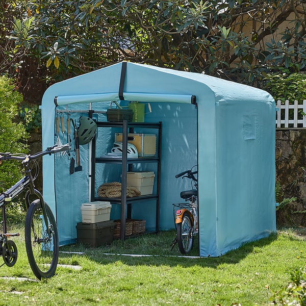 Blauer Geräteschuppen mit Fahrrädern, Regalen und Gartenzubehör auf einer Rasenfläche