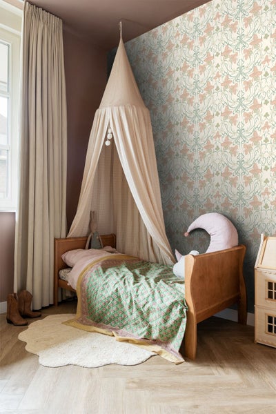 Gemütliches Kinderzimmer mit Vliestapete im floralen Jugendstil-Muster, einem Holzbett mit Baldachin und hellen Vorhängen.