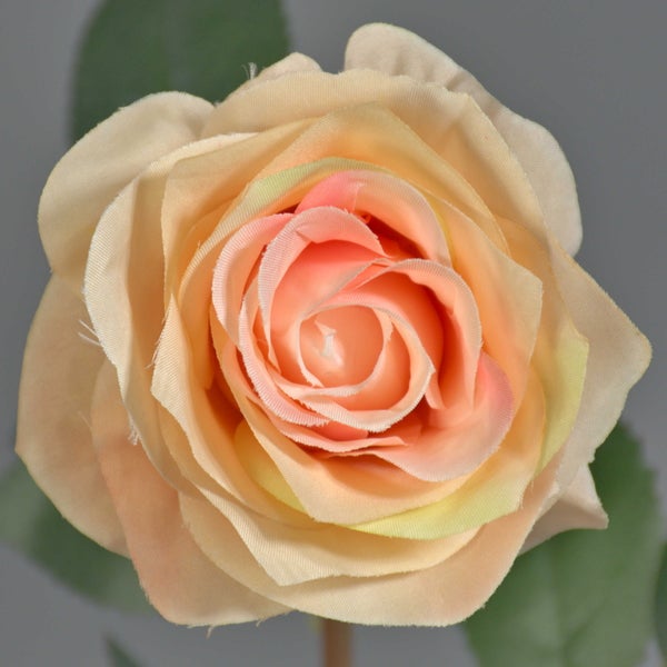 Künstliche Rose in Apricot mit grünem Stiel und Blättern aus Textil und Kunststoff.