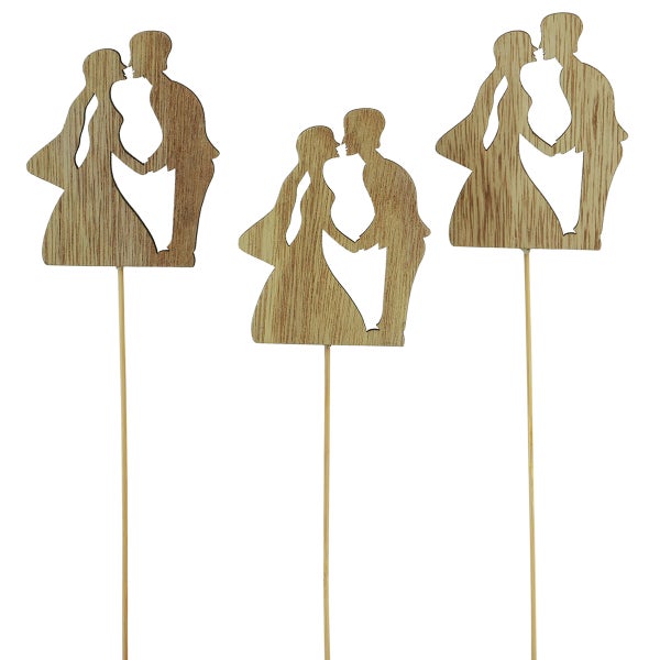 Drei Holzfiguren auf Stäben, die ein küssendes Paar darstellen, als Tortendekoration