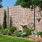 Garten mit Gabionenwand, Pflanzen und Dekorationen