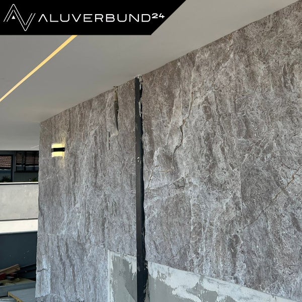 Wandgestaltung mit Wandpaneelen in Steinoptik und indirekter Beleuchtung.