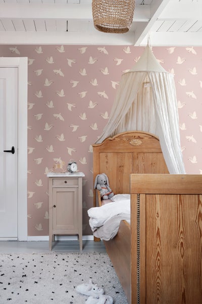 Gemütliches Kinderzimmer mit Holzbett, Nachttisch und Tapete mit Vogelmuster