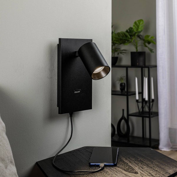 Wandleuchte mit USB-Anschluss auf einem Nachttisch mit einem Smartphone
