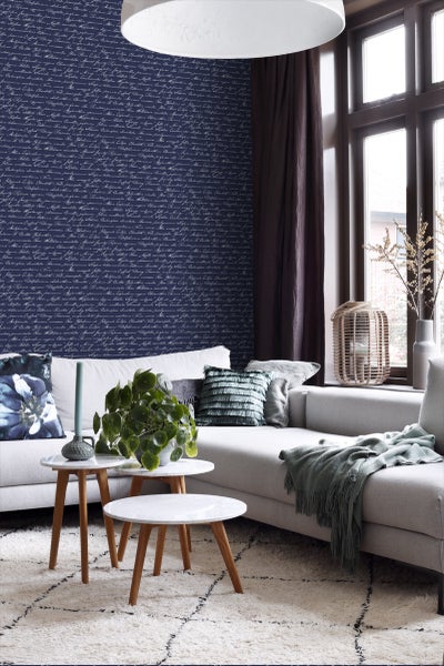 Wohnzimmer mit Sofa, Couchtischgruppe und gemusterter Tapete