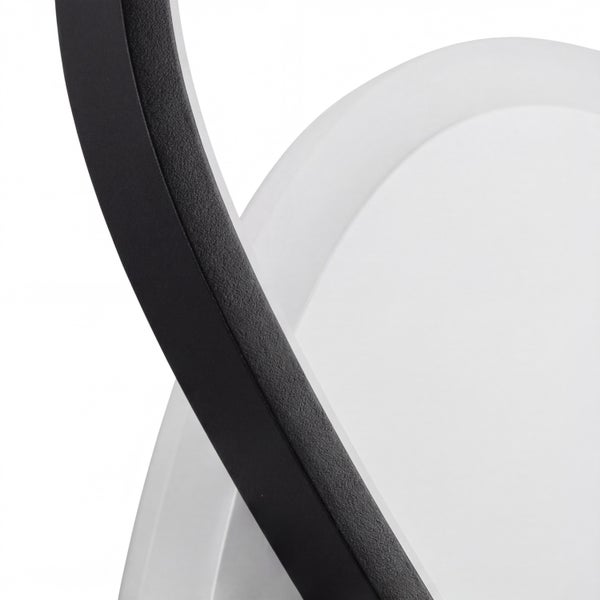 Nahaufnahme einer modernen Leuchte mit schwarzem Metallrahmen und weißem Diffusor.