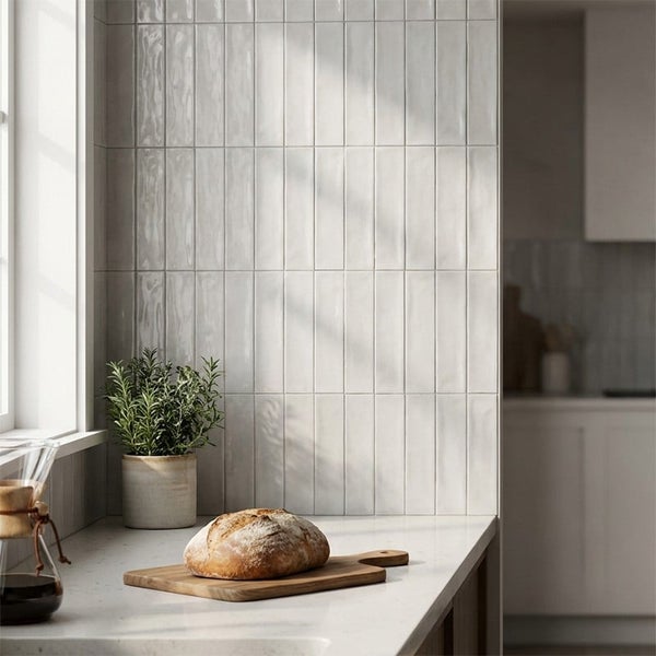 Moderne Küche mit hellen, länglichen Wandfliesen im Hochformat an der Küchenrückwand, ergänzt durch eine Arbeitsplatte aus Stein.