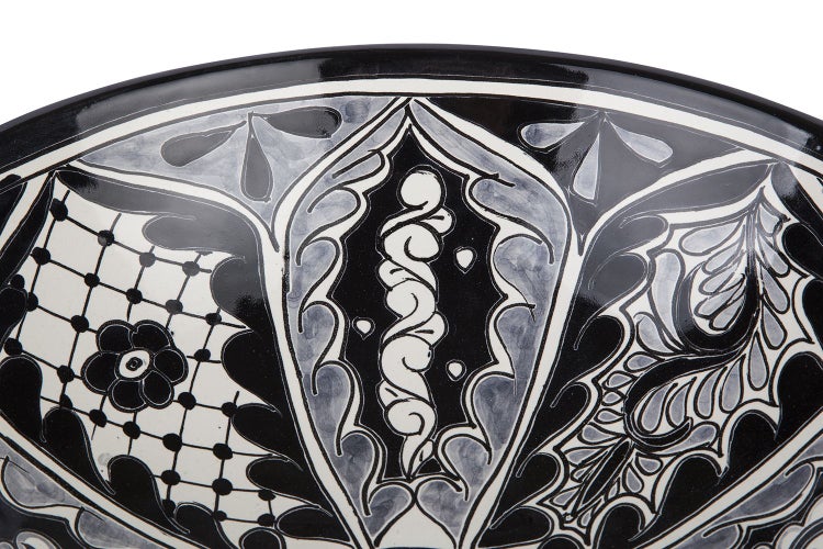 Detailansicht einer Keramikschüssel mit floralen und abstrakten Mustern.