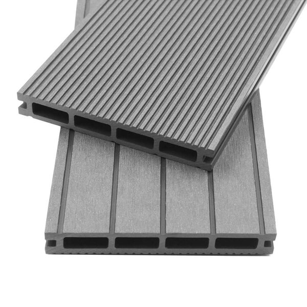 Moderne, hell gestaltete Terrasse mit Terrassendielen aus Verbundwerkstoff am Pool, umgeben von einem Garten mit Hecken und Bäumen.