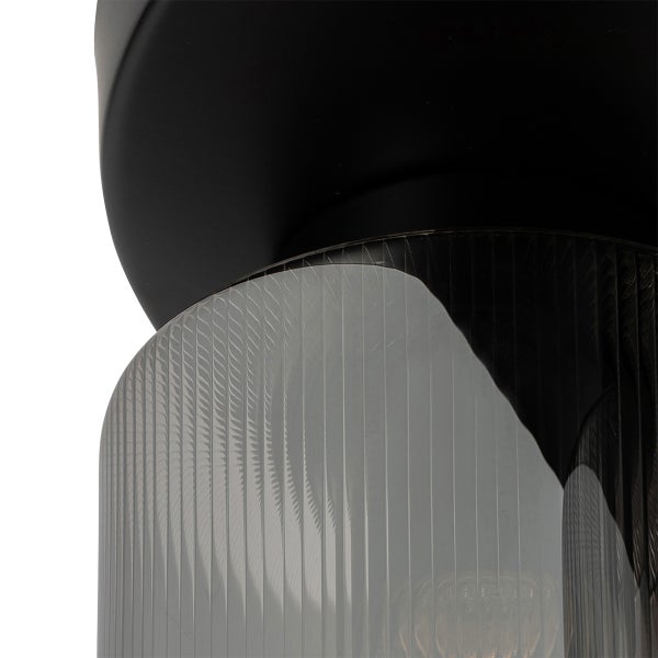 Detailaufnahme einer Leuchte mit mattschwarzer Halterung und geriffeltem Glaszylinder.