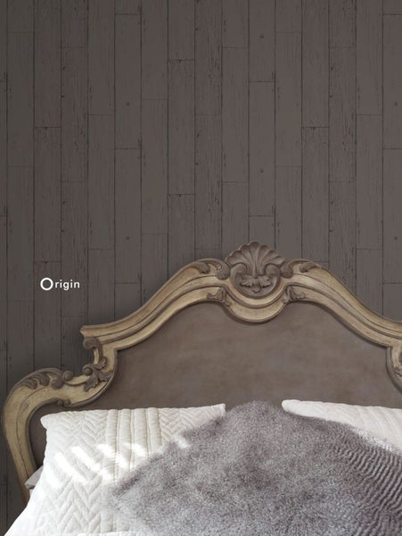 Detailaufnahme eines Bettes vor einer Wandtapete in Holzoptik