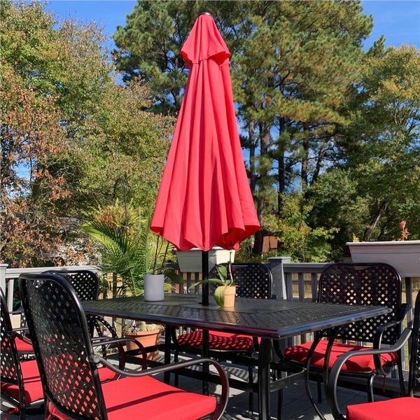 Gartensitzgruppe mit Tisch, Stühlen und geschlossenem Sonnenschirm im Freien