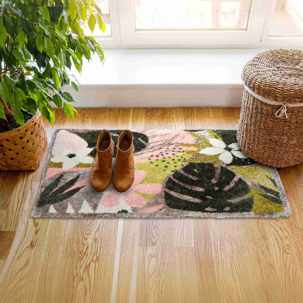 Szene mit einem gemusterten Teppich, Stiefeln, einer Pflanze und einem Korb im Flur