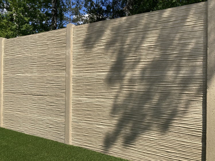 Dekorative Betonwand mit horizontaler Rillenstruktur als Gartenzaun