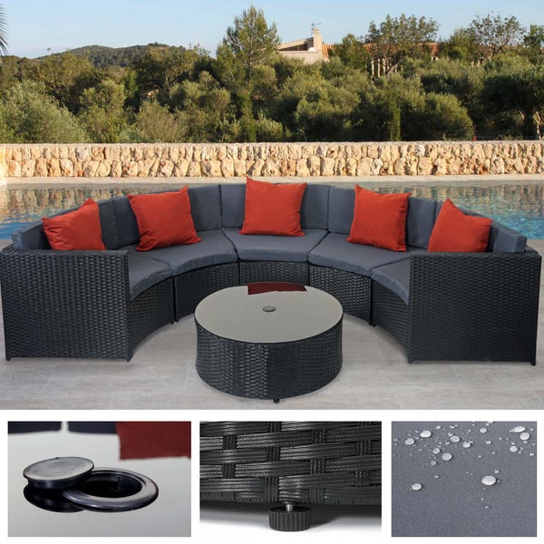 Halbkreisförmige Gartenlounge aus Polyrattan mit rundem Glastisch, grauen Sitzkissen und roten Rückenkissen.