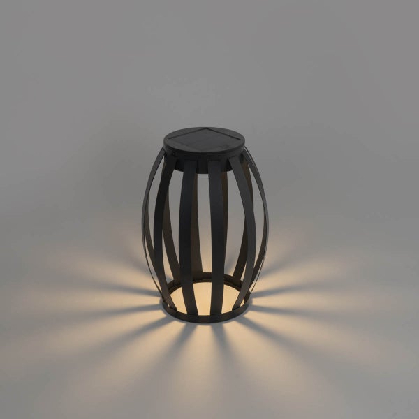 Solar-Laterne für den Garten in Schwarz mit Lamellen-Design und strahlenförmigem Lichteffekt.