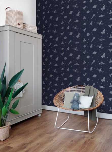 Kinderzimmer mit Weltraumtapete, Rattansessel und Kleiderschrank