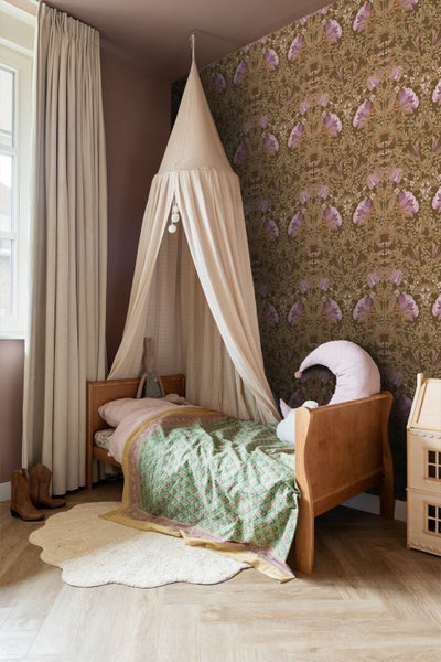 Kinderzimmer mit Bett, Baldachin und floraler Tapete