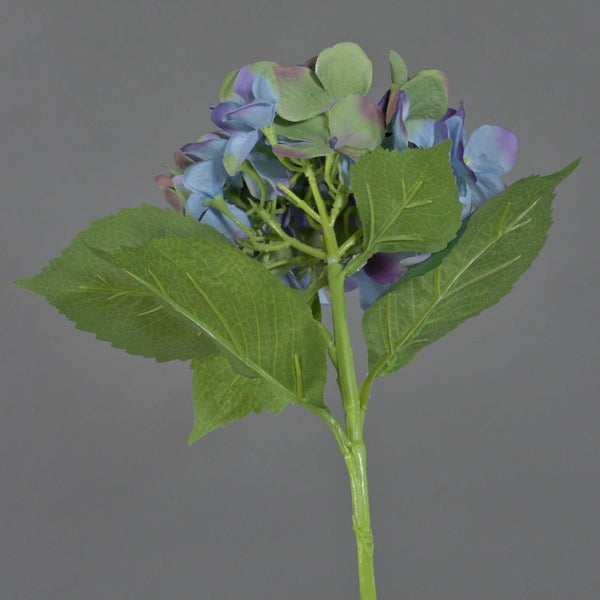 Künstliche Hortensie mit blau-violetten Blüten und grünen Blättern, Detailansicht von Stiel und Blattunterseiten.