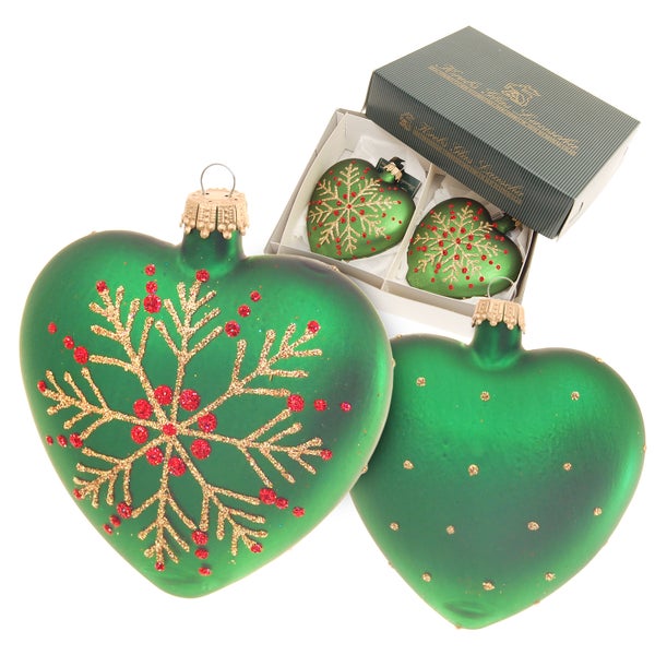 Dekorative grüne Christbaumkugeln in Herzform, einige mit Schneeflockenmuster, in einer Schachtel.