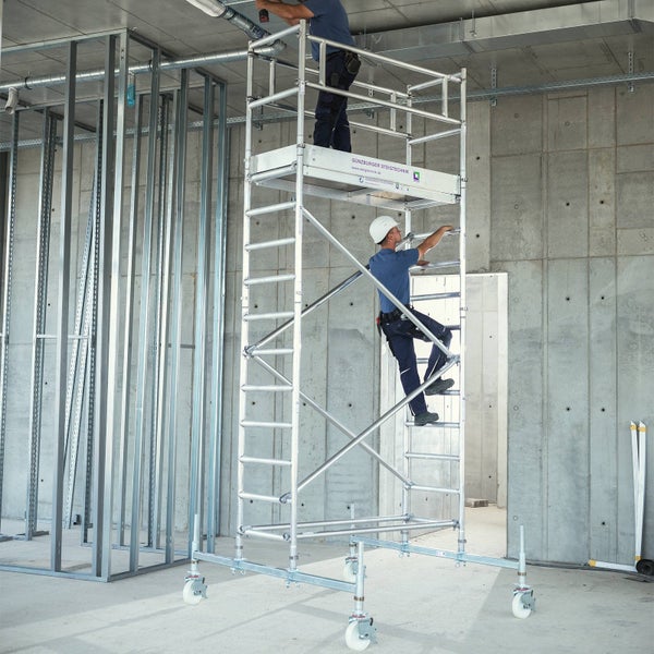 Rollgerüst mit zwei Bauarbeitern auf einer Baustelle