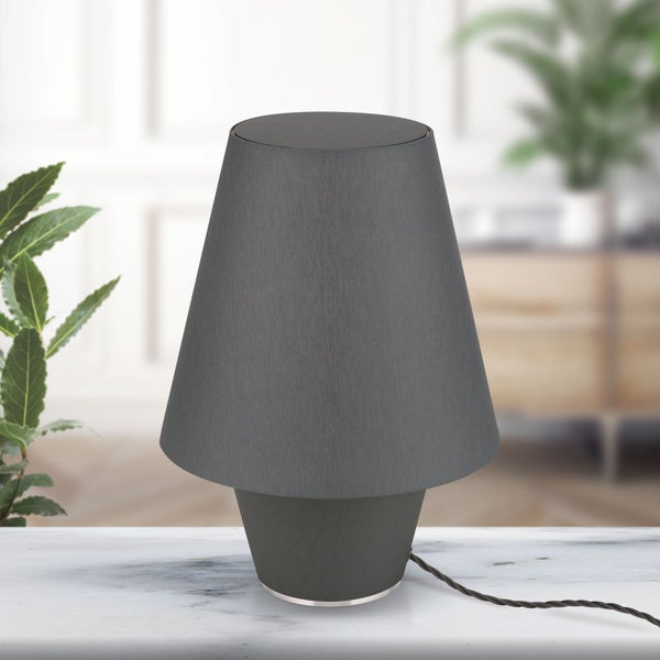 Graue Tischleuchte mit Stoffschirm auf einem Tisch