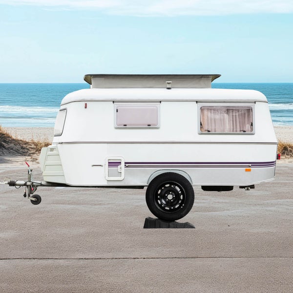 Weißer Wohnwagen auf einem Strandparkplatz