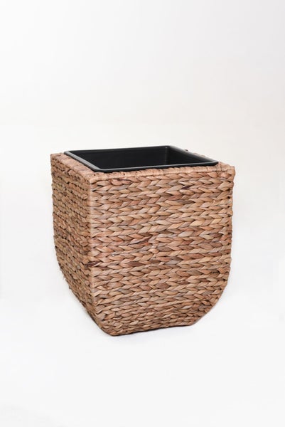 Quadratischer Pflanztopf aus geflochtener Wasserhyazinthe mit schwarzem Kunststoffeinsatz.