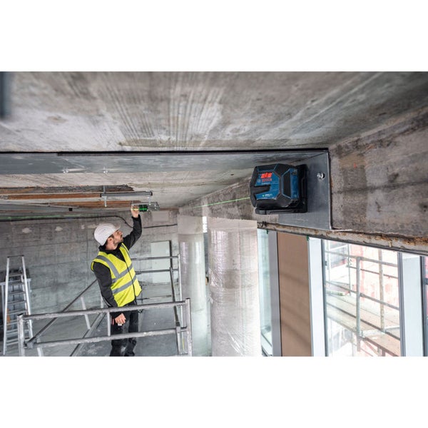 Ein Bauarbeiter justiert einen an einer Betondecke montierten Kreuzlinienlaser von Bosch.