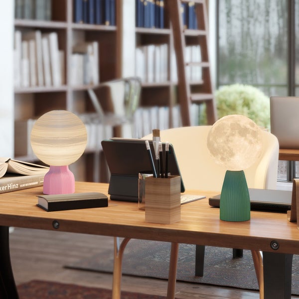 Zwei dekorative Tischleuchten mit strukturierten, kugelförmigen Schirmen auf einem Holzschreibtisch in einem organisierten Arbeitszimmer mit Regal.