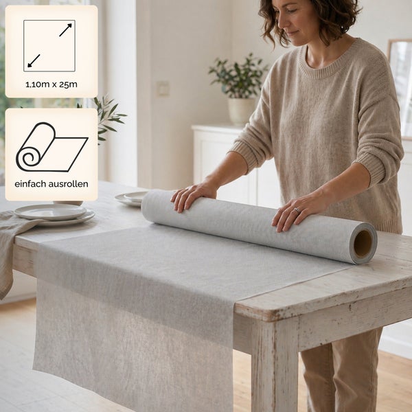 Eine Frau rollt einen grauen Tischläufer aus Vlies auf einem Holztisch aus. Maße 1,10 Meter mal 25 Meter. Einfach ausrollen.