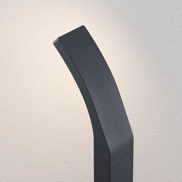 Moderne LED-Außenwandleuchte in Anthrazit mit gebogenem Design und indirektem Licht an einer Hauswand.